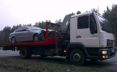 Эвакуатор МАН перевозит аварийный автомобиль Мерседес