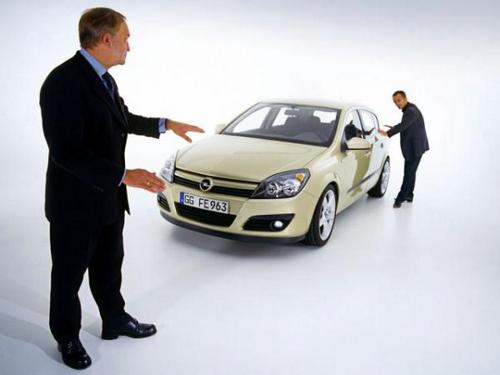 Продавец показывает автомобиль покупателю.